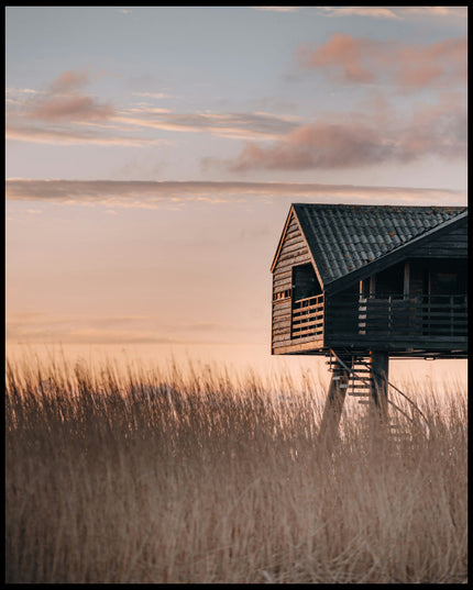 Ein Leinwandbild von einer Hütte am Strand in den Dünen bei Sonnenuntergang.