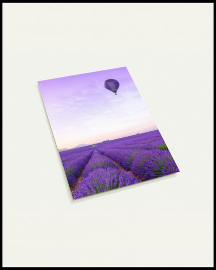 Eine Postkarte von einem Lavendelfeld und einem Heißluftballon mit lila-weißem Muster, der über dem Feld schwebt.